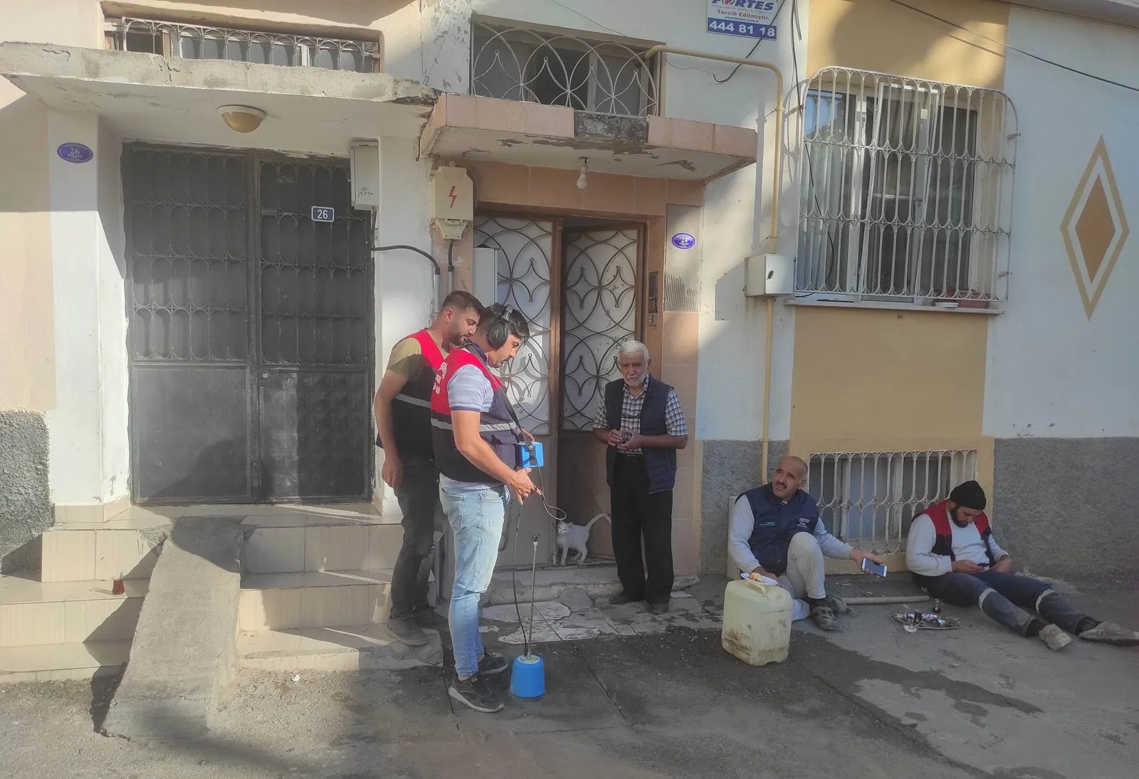 LeakExpert ekibinden bir kişi gündüz bir sokakta yer mikrofonu ve dinleme cihazıyla akustik tarama yaparken